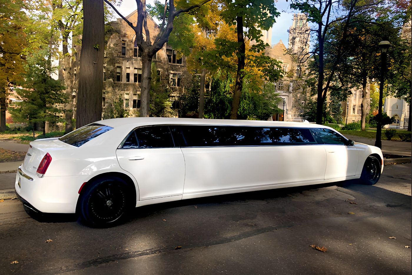 Long white limo near historic buildings.