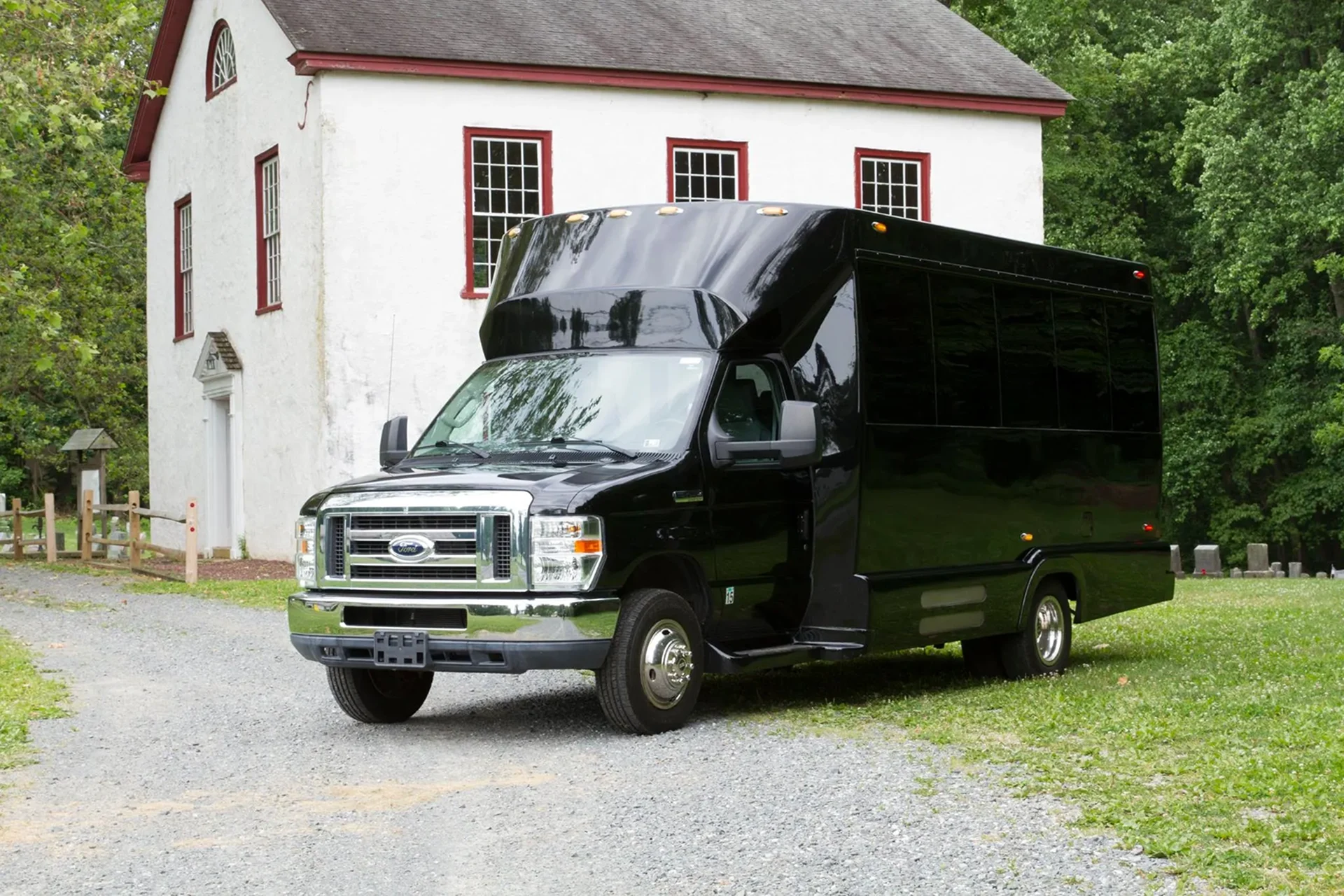 Black shuttle bus parked beside white building