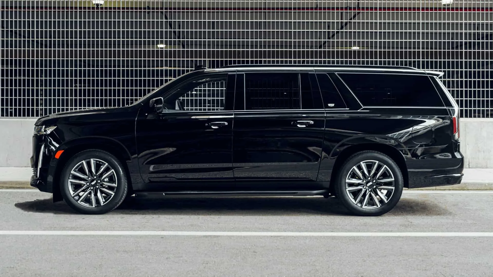 Luxury SUV parked near a metal fence.